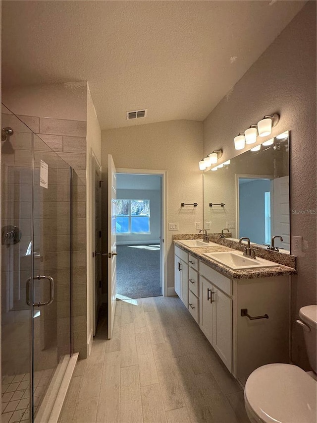 bathroom with a sink, visible vents, toilet, and a shower stall