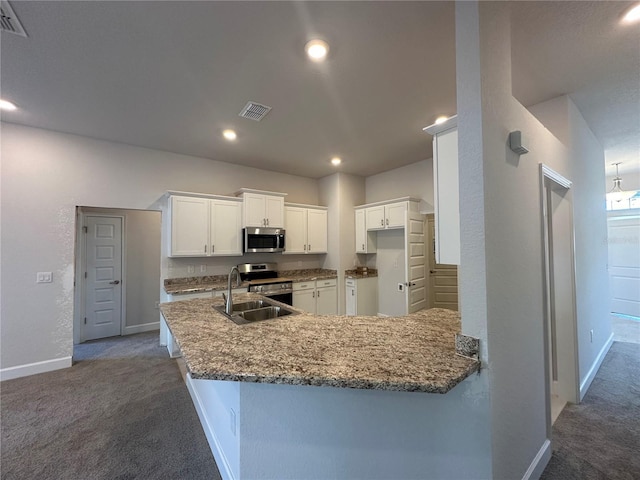 kitchen with a sink, visible vents, dark colored carpet, and stainless steel appliances