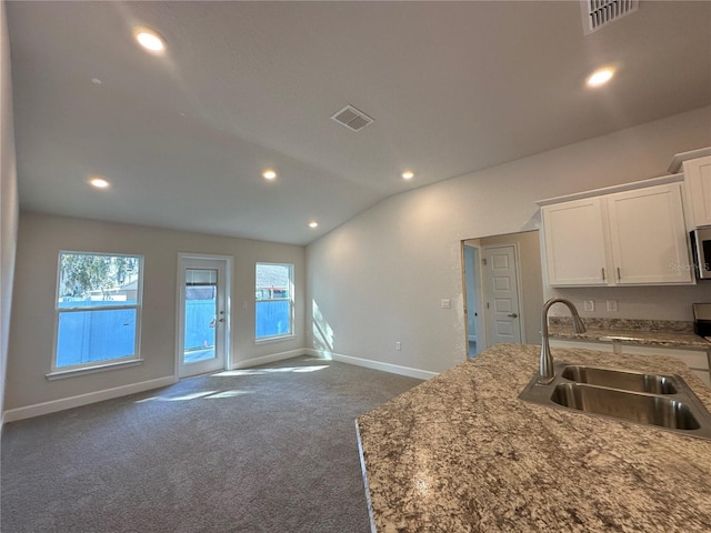 kitchen featuring a sink, visible vents, lofted ceiling, and stainless steel microwave