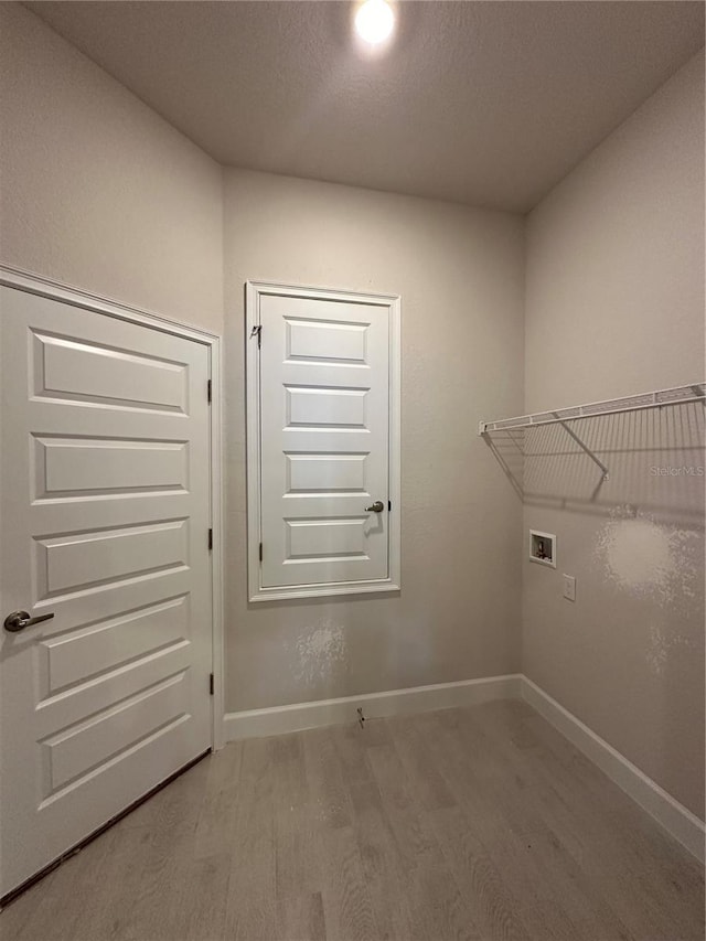 washroom with baseboards, washer hookup, laundry area, wood finished floors, and a textured ceiling