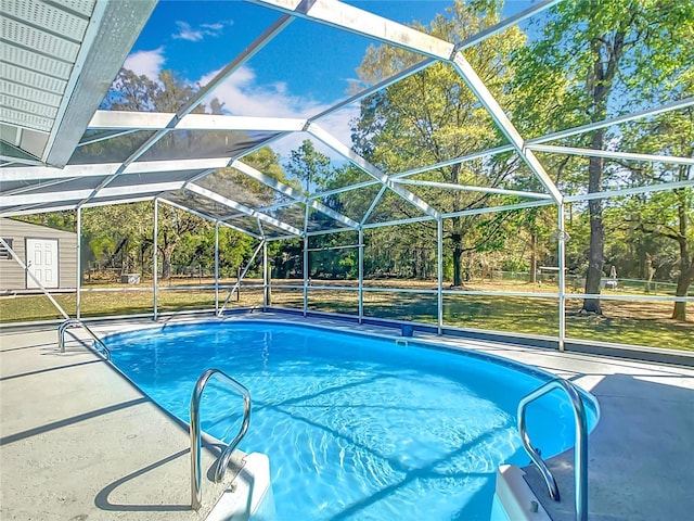 outdoor pool featuring a lanai, an outbuilding, and a shed