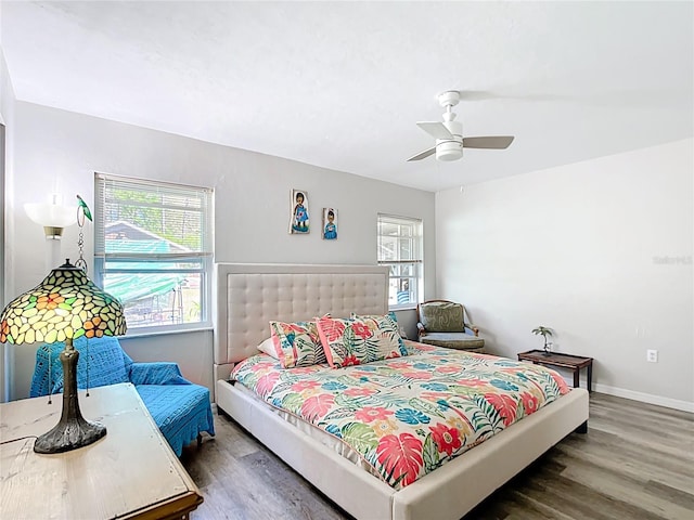 bedroom with ceiling fan, baseboards, and wood finished floors