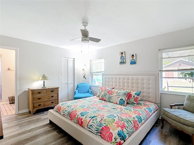 bedroom with a ceiling fan, wood finished floors, a closet, and ensuite bathroom