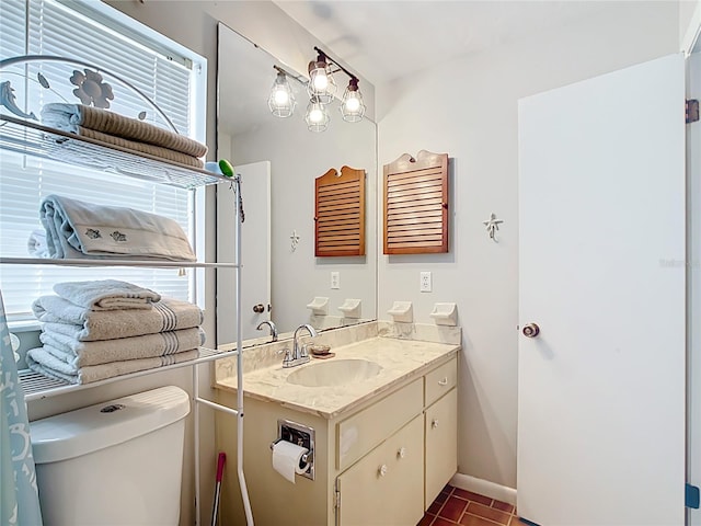 bathroom featuring baseboards, toilet, and vanity