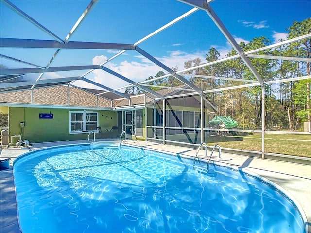 outdoor pool with a lanai and a patio area