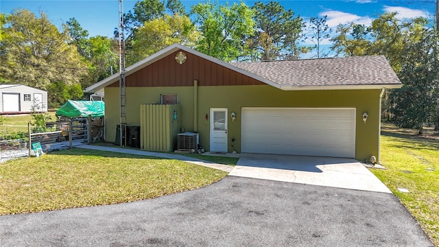 garage featuring cooling unit and driveway