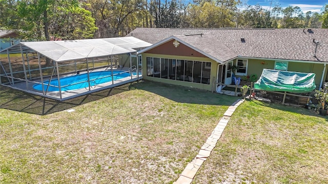 outdoor pool featuring a yard and glass enclosure