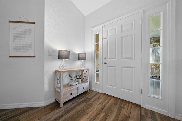 entrance foyer featuring baseboards, dark wood-type flooring, and vaulted ceiling