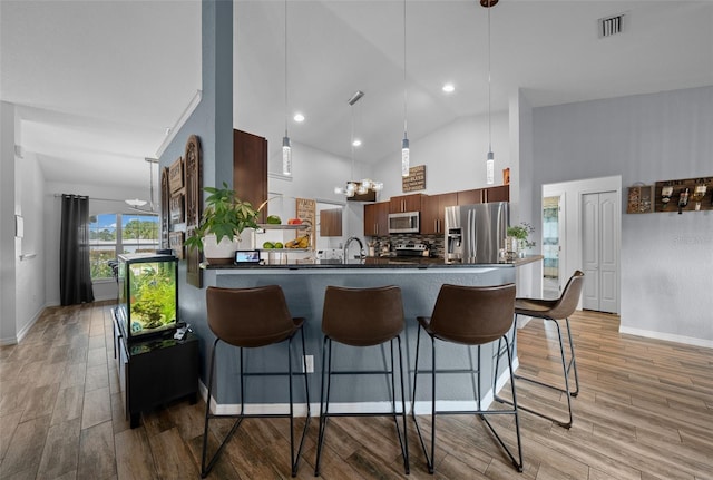 kitchen with dark countertops, appliances with stainless steel finishes, and a breakfast bar area