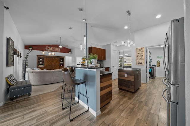 kitchen with open floor plan, dark countertops, wood finished floors, and freestanding refrigerator