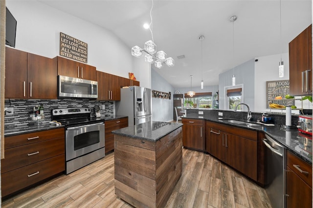 kitchen featuring tasteful backsplash, stainless steel appliances, light wood-style floors, and a sink