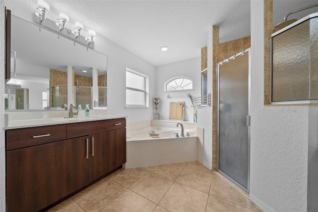 full bathroom with tile patterned flooring, vanity, a stall shower, and a textured ceiling