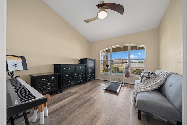 sitting room with baseboards, wood finished floors, a ceiling fan, and vaulted ceiling