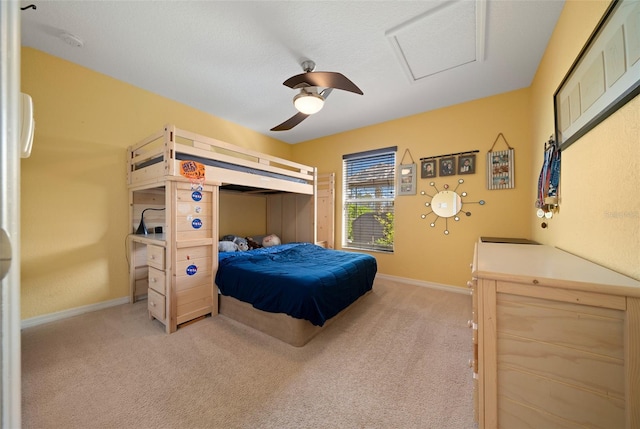 bedroom with light colored carpet, attic access, baseboards, and ceiling fan