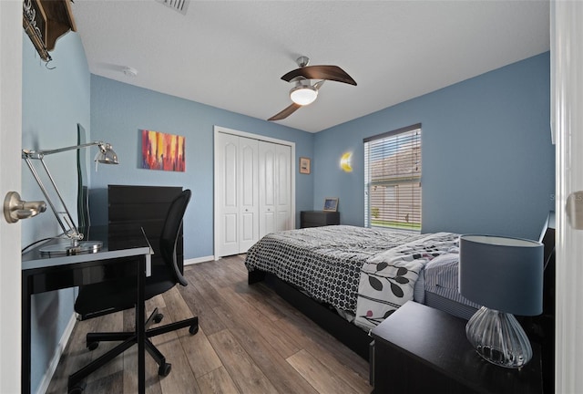 bedroom featuring ceiling fan, a closet, baseboards, and wood finished floors