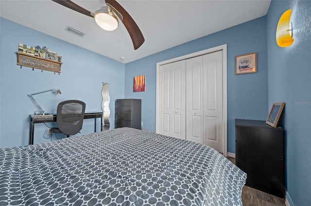 bedroom with a closet, visible vents, ceiling fan, and wood finished floors