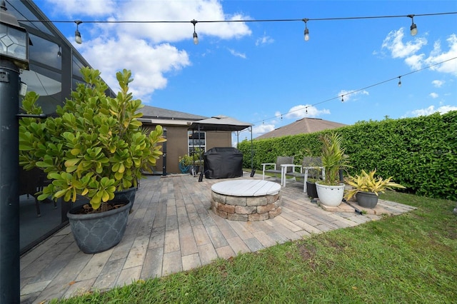 view of patio / terrace with a lanai and a fire pit