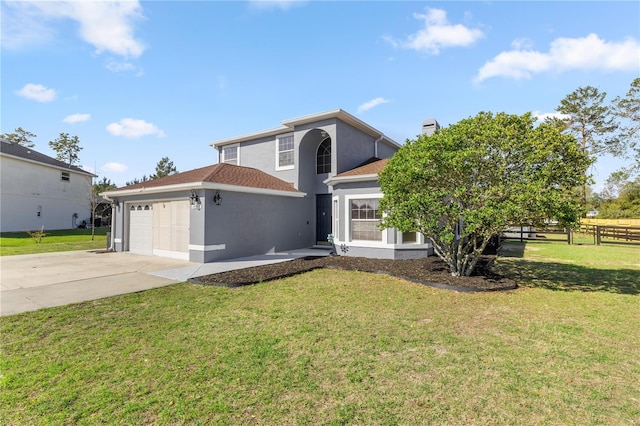 traditional-style home with stucco siding, a front lawn, and driveway