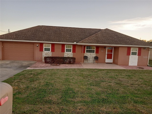 view of front of home featuring a shingled roof, a front lawn, stucco siding, stone siding, and an attached garage