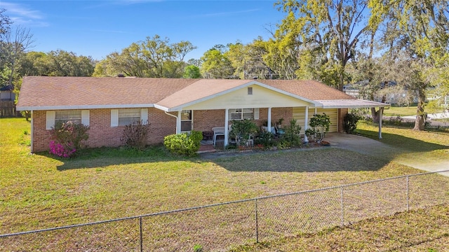 view of front of house featuring brick siding, driveway, fence private yard, and a front lawn