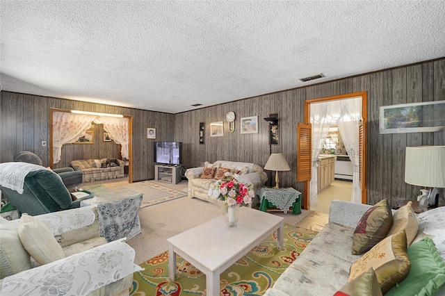 carpeted living room with ornamental molding, visible vents, and a textured ceiling