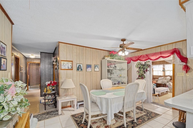 dining room with a textured ceiling, light tile patterned flooring, and crown molding