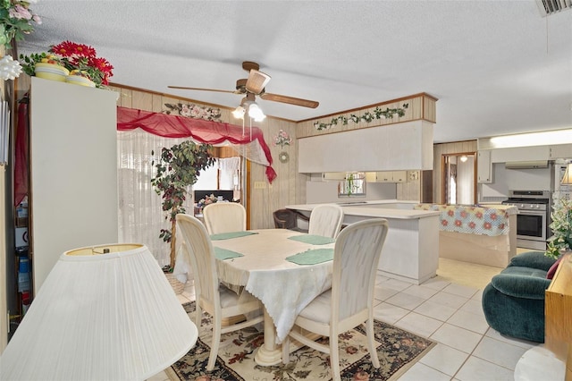 dining space with visible vents, ornamental molding, a textured ceiling, light tile patterned floors, and ceiling fan