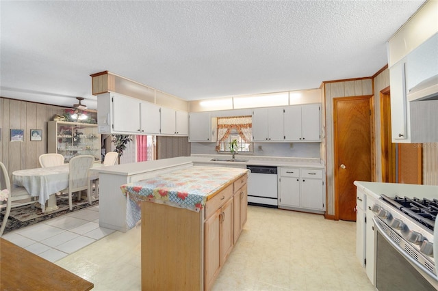 kitchen with gas range oven, light countertops, light floors, and white dishwasher