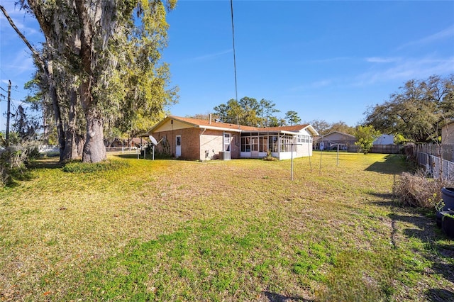 view of yard with fence and a sunroom