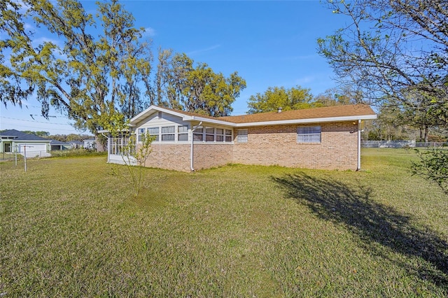 rear view of house featuring brick siding and a lawn