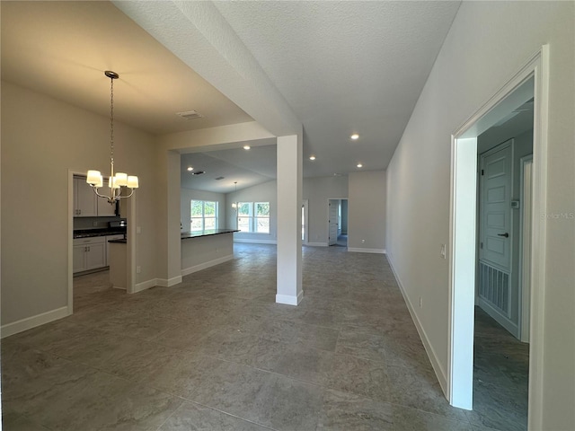 spare room featuring recessed lighting, a textured ceiling, baseboards, and an inviting chandelier