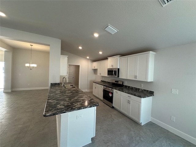 kitchen with visible vents, lofted ceiling, a sink, white cabinets, and appliances with stainless steel finishes