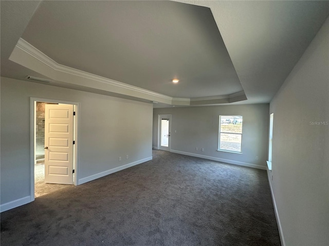 empty room with visible vents, baseboards, ornamental molding, a raised ceiling, and dark colored carpet