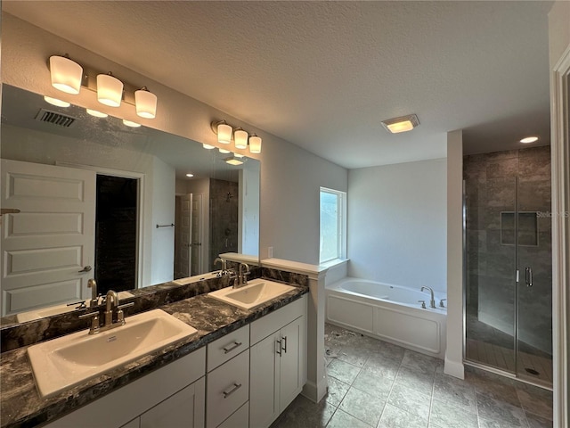 bathroom with a stall shower, a bath, visible vents, and a sink