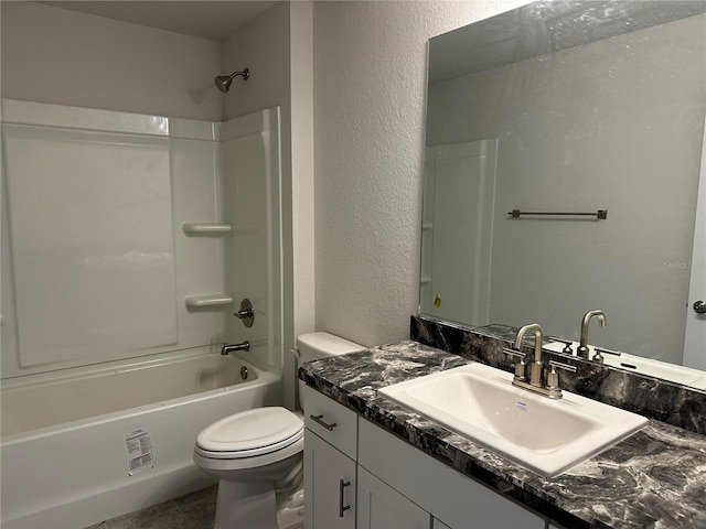 bathroom featuring shower / bathtub combination, toilet, vanity, and a textured wall