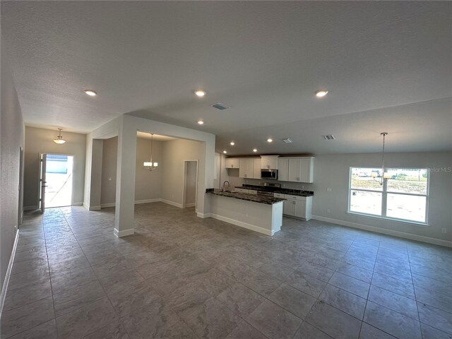 4397 SW 90th Pl, Ocala, FL 34476 - kitchen with a chandelier, open floor plan, stainless steel microwave, white cabinets, and recessed lighting