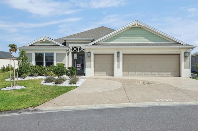 view of front facade with a front yard, driveway, roof with shingles, an attached garage, and stucco siding