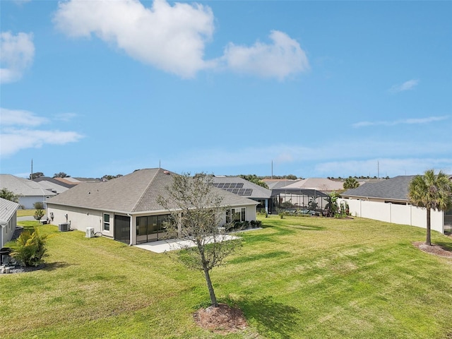 view of yard with central air condition unit, a sunroom, a residential view, and fence