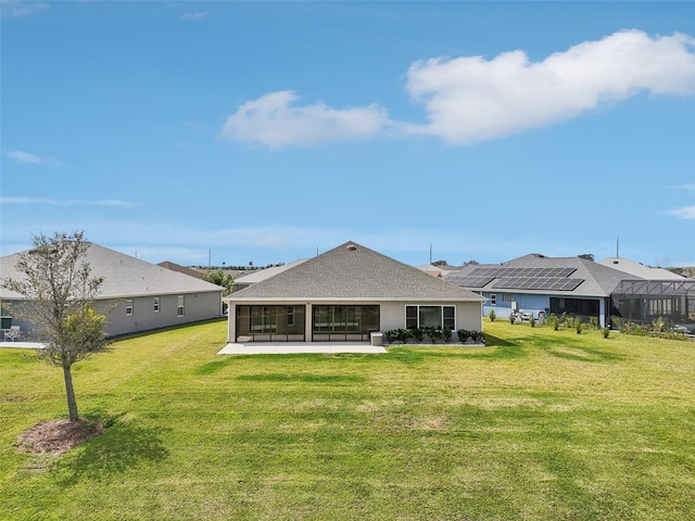 back of property with a patio area, a lawn, and a sunroom