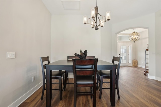 dining area featuring visible vents, baseboards, a chandelier, arched walkways, and dark wood-style floors