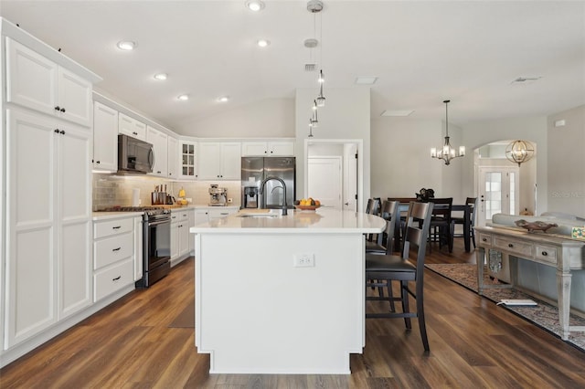 kitchen featuring a sink, decorative backsplash, dark wood-type flooring, and appliances with stainless steel finishes