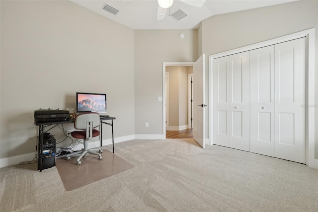 carpeted office space featuring visible vents, baseboards, and vaulted ceiling