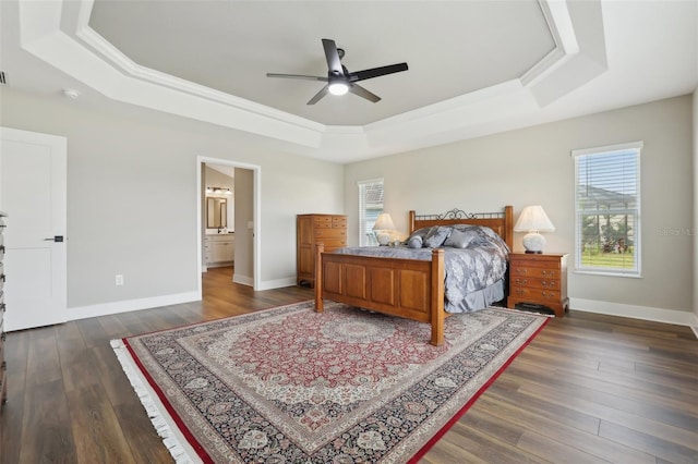 bedroom featuring dark wood-style floors, baseboards, and a tray ceiling