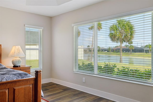 bedroom with dark wood finished floors and baseboards