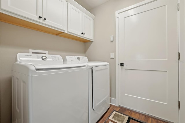 laundry room featuring cabinet space, wood finished floors, and washing machine and clothes dryer