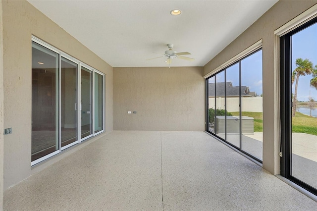 unfurnished sunroom with a ceiling fan