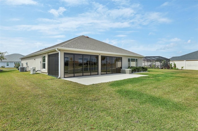 back of property with central AC unit, a lawn, and a patio