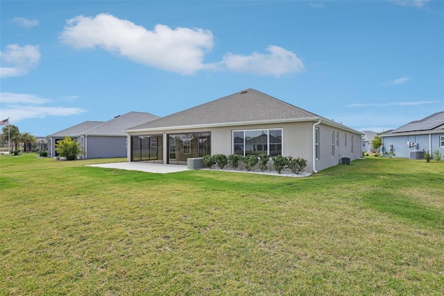 back of house with a patio area, a lawn, and stucco siding