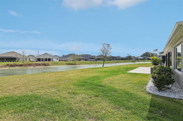 view of yard featuring a residential view and a water view