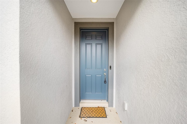 entrance to property featuring stucco siding